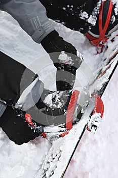 Person strapping on snowboard.