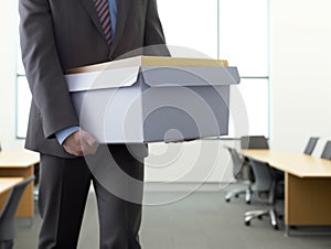 A person in a suit carrying a box of resumes to a job interview.. AI generation