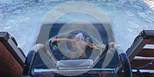 Person surfacing in an ice-hole after a swim