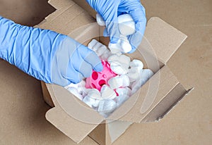 Person with surgical gloves despatch  a package with children`s toys