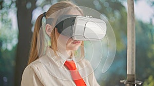 Person with sword posing at camera. Young woman in school uniform in vr glasses with japanese sword katana poses in