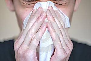 A person with symptoms of the disease presses a handkerchief to his face. Sneezing, bouts of coughing photo