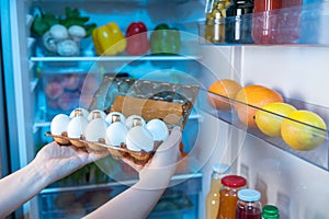 Person taking fresh eggs from fridge