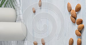 Person taking a glass with almond milk, Close-up video of vegan drink made of almond nuts placed on white table, 4k