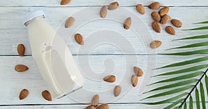 Person taking a glass with almond milk from table, vegan drink placed on table, alternative milk drink, slow motion