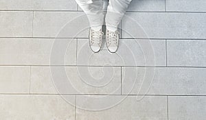 Person taking photo of his feet stand on concrete floor