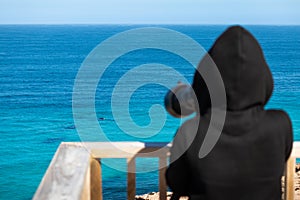 Person taking pictures of whales at the ocean with a zoom lens on a camera. Group of whales, blurry person at foreground with