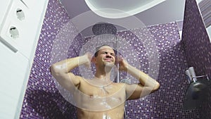 A person taking a shower washes his hair . Body care at home. daily procedure for adults.
