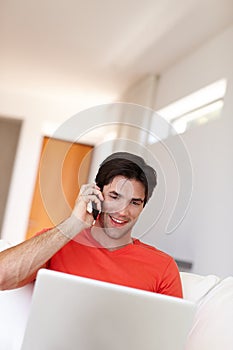 Person, talking or phone call in living room with laptop for business, entertainment or work from home. Man, notebook