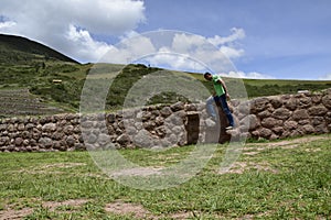 A person on the territory Inca terraces of Moray. Moray is an archaeological site near the Sacred Valley