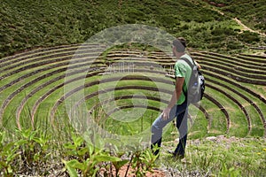 A person on the territory Inca terraces of Moray. Moray is an archaeological site near the Sacred Valley