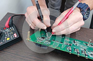 Person testing pcb by multimeter