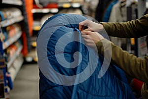 person testing a sleeping bag instore