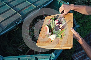 Person throws organic waste from his kitchen into compost heap. Composting - eco-friendly recycling technology. Sustainable living