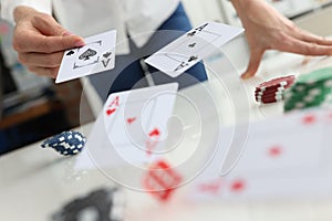 Person throws playing cards on table closeup