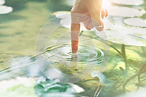 Person touches the water with his hand