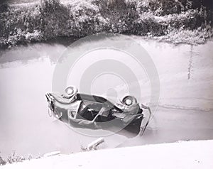 Person trapped in overturned car in swamp