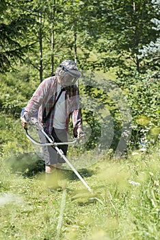 Person trimming the lawn with a weed eater