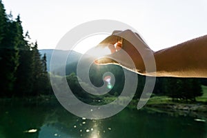 Person trying to hold a sun over the pond in Ruzomberok, Slovakia