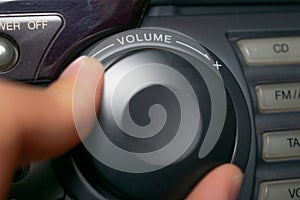 A person turning the volume wheel up or down the focus is on the word `volume` written on the device.