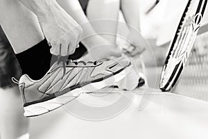 Person Tying His Shoe before a Game of Tennis