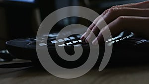 Person typing on a black keyboard, detail