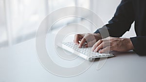 Person typing on a computer keyboard, businessman is working in a startup company's office, he is typing messages to his