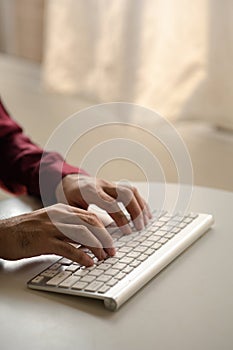 Person typing on a computer keyboard, businessman is working in a startup company's office, he is typing messages to his