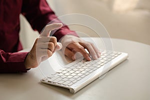 Person typing on a computer keyboard, businessman is working in a startup company's office, he is typing messages to his