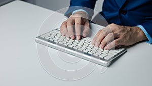 Person typing on a computer keyboard, businessman is working in a startup company's office, he is typing messages to his