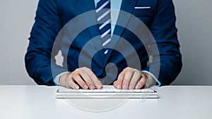 Person typing on a computer keyboard, businessman is working in a startup company's office, he is typing messages to his