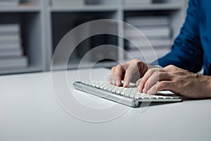 Person typing on a computer keyboard, businessman is working in a startup company's office, he is typing messages to his