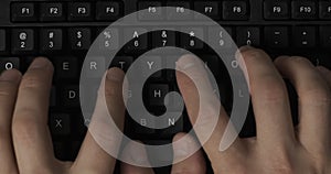 Person typing on computer keyboard. Man is working on tablet computer. Writing text on keypad. Close up.