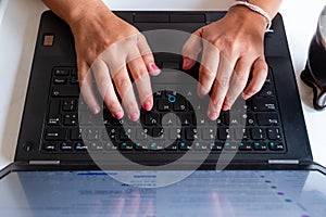 A person is typing on a laptop keyboard