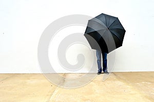 Person with an umbrella in front o a wall