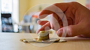 A person uses his fingers to flick a coin stack.