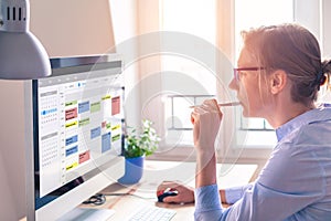 Person using calendar on computer to improve time management, plan appointments, events, tasks and meetings efficiently, improve