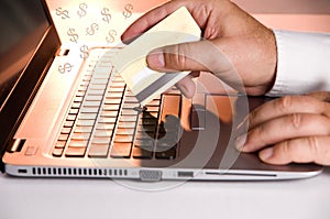 Person Using a Credit Card and a Laptop making a Purchase on the Internet