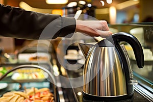 person using electric kettle at a selfservice hotel breakfast area photo