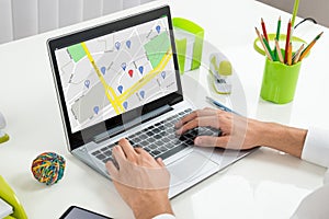 Person Using GPS Map On Laptop