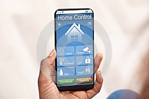 Person Using Home Control System On Mobile Phone