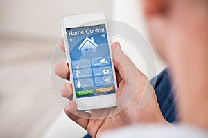 Person Using Home Control System On Mobilephone