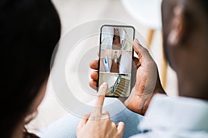 Person Using Home Security System On Mobile Phone