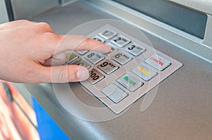 Person is using keypad and entering pin code in ATM machine. Banking concept