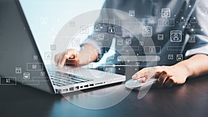 A person using a laptop and computer mouse with floating digital interface icons, representing online technology, data management