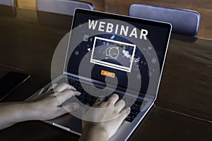 Person using a laptop computer for online training webinars.
