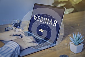 Person using a laptop computer for online training webinars.