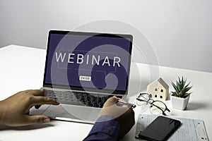 Person using a laptop computer for online training webinars.