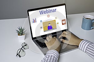Person using a laptop computer for online training webinars.