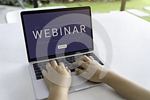 Person using a laptop computer for online training webinars.